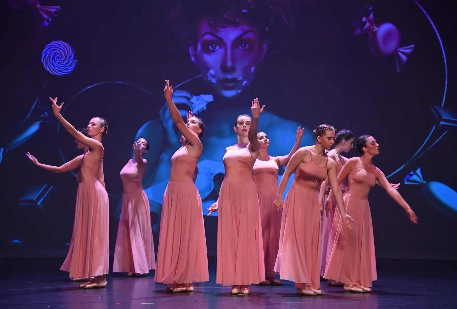 Spectacle de fin d'année - chorégraphie des adolescentes de Danse Passion sur scène, robes saumon, projection scénographique en fond.